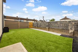 a yard with a retaining wall and green grass at North Dublin Premier Oasis in Dublin