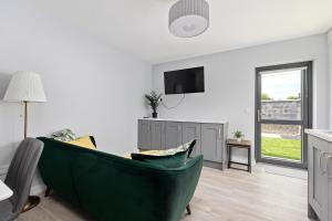a living room with a green couch and a tv at North Dublin Premier Oasis in Dublin