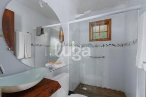 a white bathroom with a sink and a mirror at Suite Top – Cyclists' Paradise in Gramado +14 photos