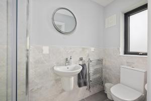 a white bathroom with a sink and a mirror at North Dublin Premier Oasis in Dublin +14 photos