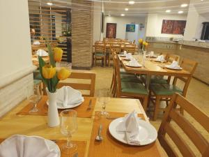 a restaurant with wooden tables with yellow flowers on them at Hotel Bello Veracruz in Veracruz