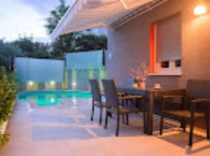 a patio with a table and chairs and a pool at Apartment Didi in Trogir