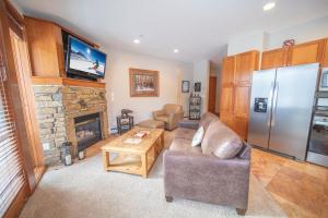 a living room with a couch and a refrigerator at Antlers Gulch 106 by SummitCove Lodging in Colorado in Keystone