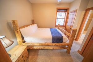 a bedroom with a wooden bed in a room at Antlers Gulch 106 by SummitCove Lodging in Colorado in Keystone