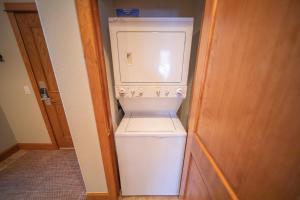 a small white washer and dryer in a room at Antlers Gulch 106 by SummitCove Lodging in Colorado in Keystone