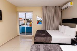a bedroom with a large bed and a large window at Brion City Hotel BW Signature Collection in Willemstad