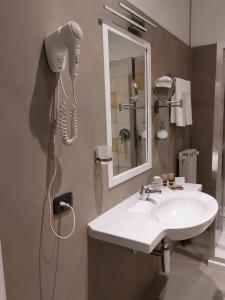 a bathroom with a sink and a blow dryer at Dependance Pesce d'Oro in Verbania +22 photos
