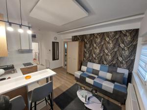 a kitchen and a living room with a couch at Oaza Apartmani Jakovo HERA in Jakovo