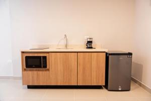 a kitchen with a sink and a refrigerator at Alcaré Rooms Cartagena in Cartagena de Indias