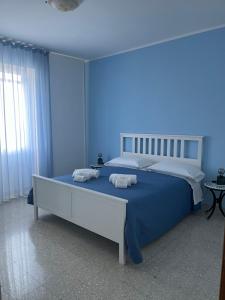 a blue bedroom with a bed with towels on it at Ambra Holiday House in Furore