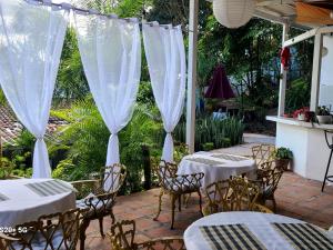 a patio with tables and chairs with white curtains at Hotel suites Las Abuelas in Copán Ruinas +4 photos