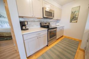 a small kitchen with white cabinets and a microwave at Argentine 1504 by SummitCove Lodging in Colorado in Keystone +32 photos
