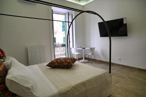 a bedroom with a bed with a television and a table at La Casa del Faro in Taranto