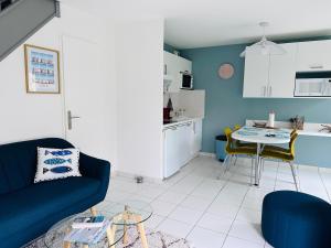 a living room with a couch and a table at Cottage en baie in Cayeux-sur-Mer