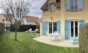 a patio with a table and chairs in a yard at Cottage en baie in Cayeux-sur-Mer