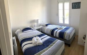 two beds with towels on them in a room at Cottage en baie in Cayeux-sur-Mer