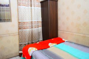 a bedroom with a bed and a wooden cabinet at Kompass - Home Stay in Dhaka