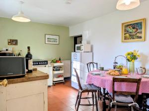 a kitchen with a table and a kitchen with a refrigerator at Blackbird Cottage near Appledore in Bideford