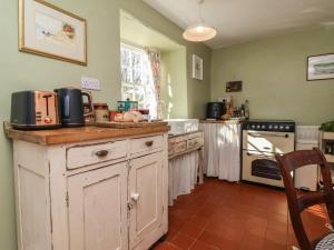 a kitchen with an old wooden island with a stove at Blackbird Cottage near Appledore in Bideford +27 photos