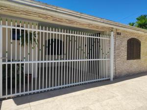 a white fence in front of a building at Oásis - Casa com Piscina e Churrasqueira in Pontal do Paraná
