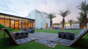 a backyard with a table and chairs and a building at قو اب إليت in Abā al Kibāsh