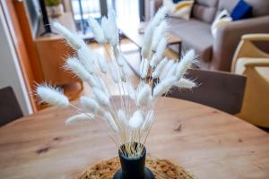 a vase filled with white feathers sitting on a table at Allotjament el Pont in Camprodon