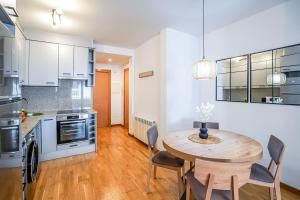 a kitchen and dining room with a wooden table and chairs at Allotjament el Pont in Camprodon