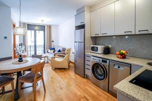 a kitchen and living room with a table and a microwave at Allotjament el Pont in Camprodon