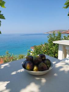 a bowl of fruit sitting on a table with the ocean at Qeparo Antonio Rooms in Qeparo
