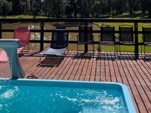 a swimming pool with chairs next to a fence at Pousada Caminho do Lago in Rio Rufino +72 photos