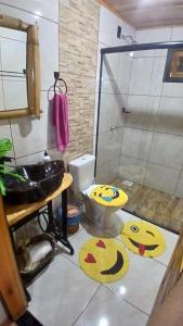 a bathroom with two smileys on the floor at Pousada Caminho do Lago in Rio Rufino