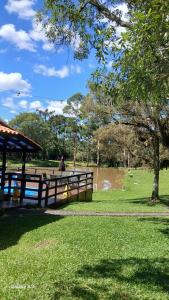 a park with a fence and a pond and trees at Pousada Caminho do Lago in Rio Rufino