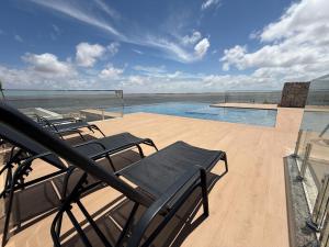 a deck with chairs and a swimming pool at Hotel London Santarem in Santarém