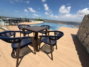 a table and chairs on a patio with a pool at Hotel London Santarem in Santarém