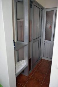 a bathroom with a walk in closet with glass doors at Fogo Island in São Filipe