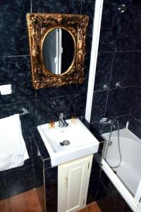 a bathroom with a sink and a mirror and a tub at Fogo Island in São Filipe