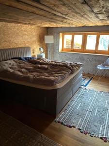 a large bed in a room with a rug at Le refuge boisé in Hérémence