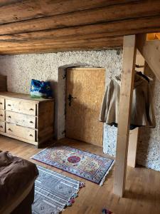 a room with a bed and a door with a rug at Le refuge boisé in Hérémence