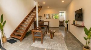 a living room with a wooden staircase and a table at Yaakun in Bacalar