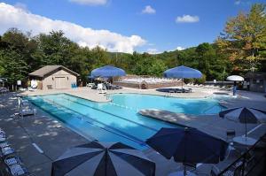 a large swimming pool with umbrellas and chairs at Oma's Beech House in Beech Mountain