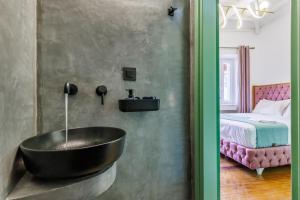 a bathroom with a black bath tub next to a bed at Larimis House in Loutraki +50 photos
