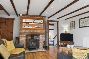 a living room with a brick fireplace and a tv at 4 Bed in Newport oc-88913 in Porchfield