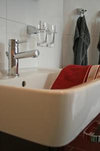 un fregadero blanco con una toalla roja en la pared en Villa Harmonie W2, en Göhren-Lebbin