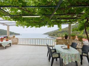 a patio with tables and chairs and a view of the ocean at Villa Azure Saplunara in Saplunara