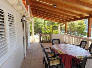 a patio with a table and chairs on a porch at Villa Azure Saplunara in Saplunara