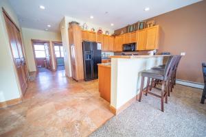 a kitchen with wooden cabinets and a counter top at Antlers Gulch 303 by SummitCove Lodging in Colorado in Keystone