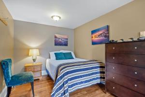 a bedroom with a bed and a chair and a dresser at Chic Midstream Studio WiFi Parking in St. John's