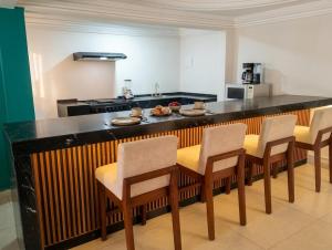 a kitchen with a table with chairs and a counter top at FIKA Apartamentos Elite in Toluca