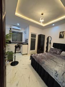 a bedroom with a large bed and a kitchen at Studio apartment-Akilo in Lagos +1 photo