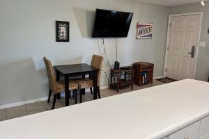 a kitchen with a table and two chairs and a television at Tropical Isle #112 in Fort Walton Beach +35 photos